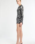 Woman wearing a black and white patterned dress on a white background