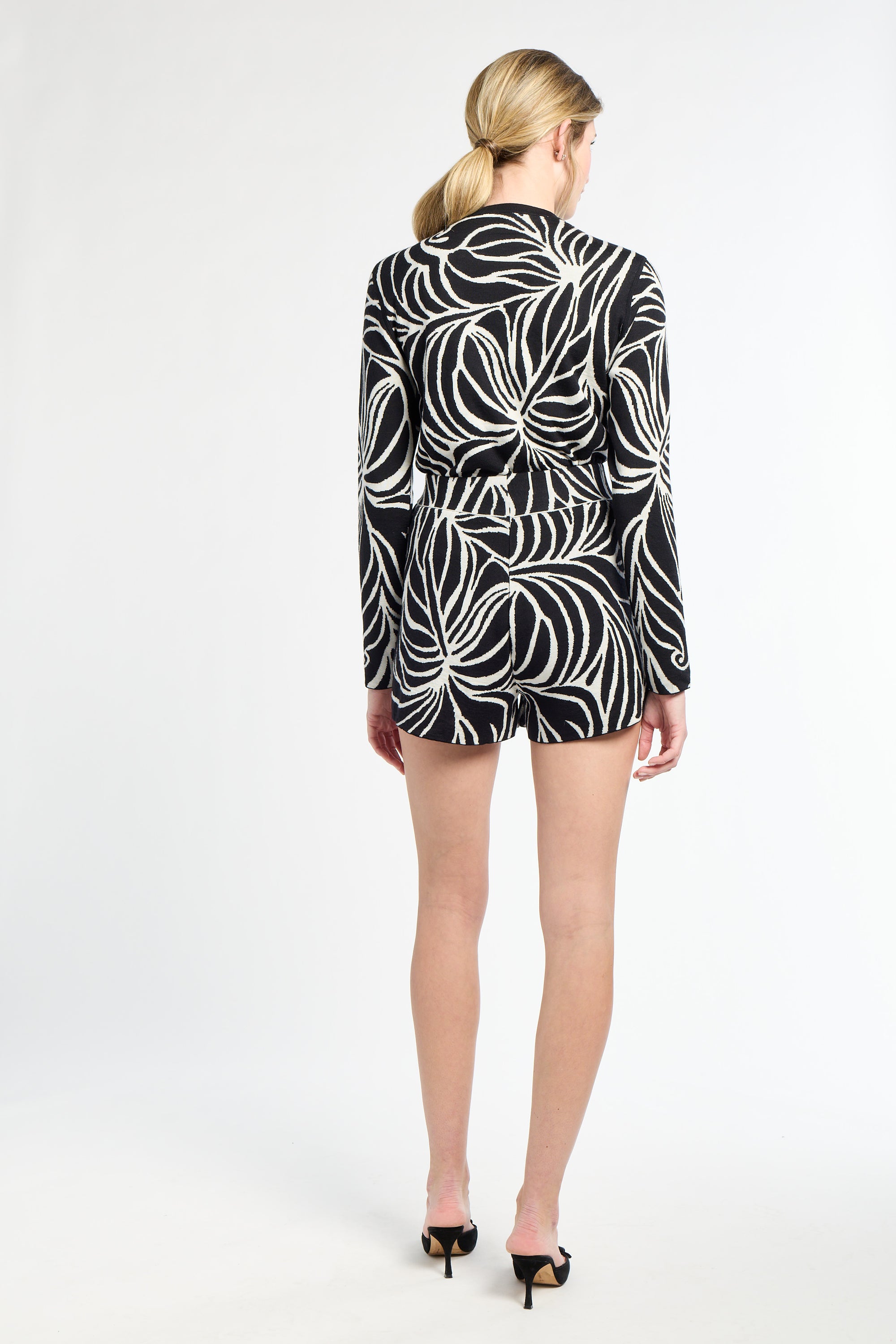 Person wearing a black and white patterned dress on a white background