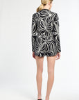 Person wearing a black and white patterned dress on a white background
