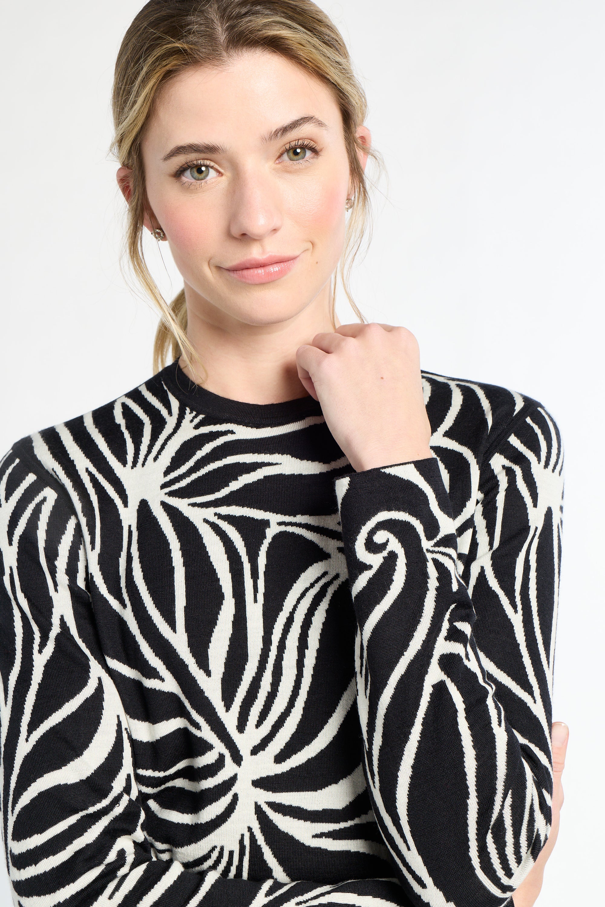 Woman wearing a black and white patterned sweater on a white background