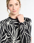 Woman wearing a black and white patterned sweater on a white background