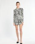 Woman wearing a black and white patterned dress on a white background