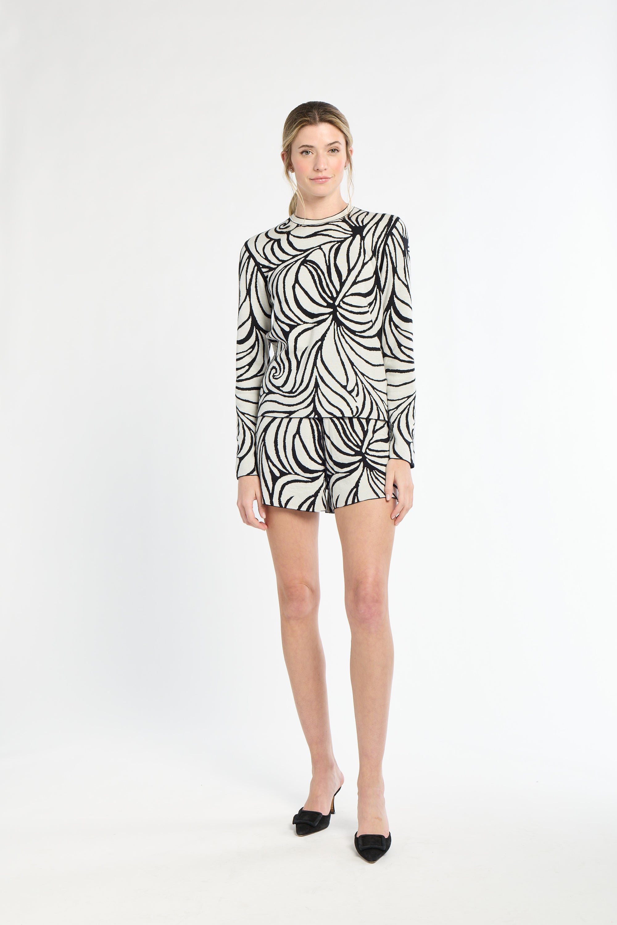 Woman wearing a black and white patterned dress on a white background