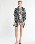 Woman wearing a black and white patterned dress on a white background