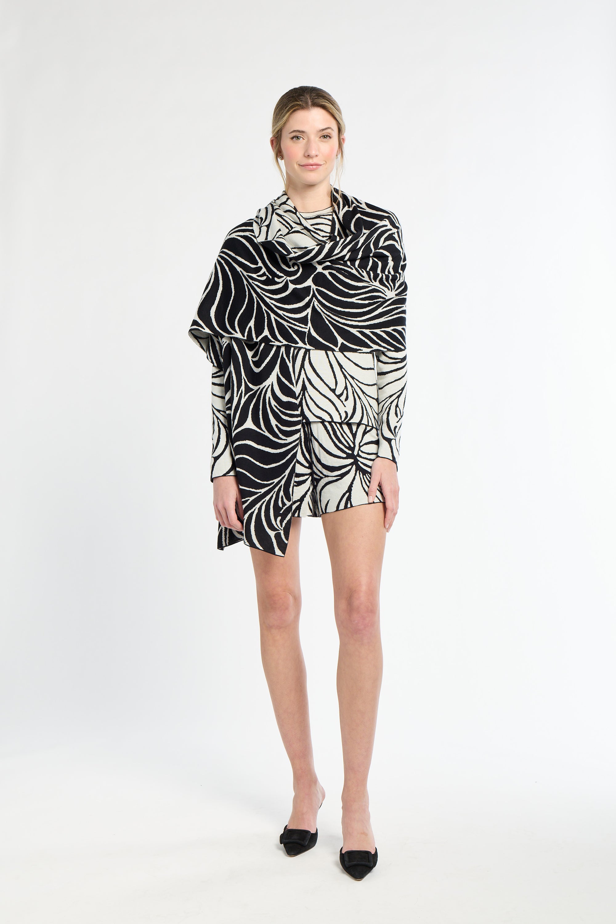 Woman wearing a black and white patterned dress on a white background