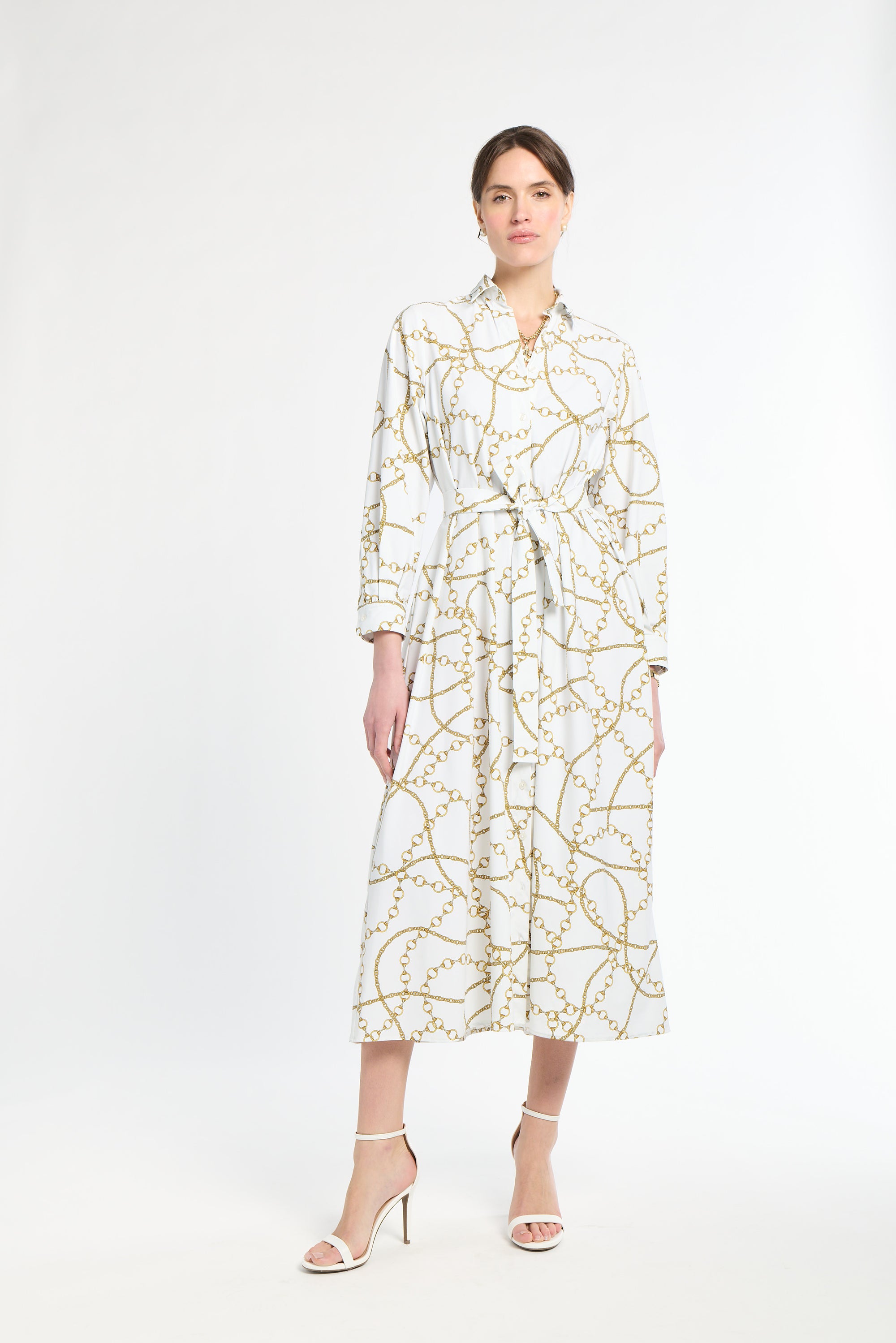 Woman wearing a white dress with gold pattern on a white background