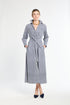 Woman wearing a long blue and white striped dress on a white background