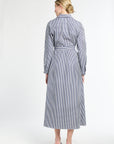 Woman wearing a long blue and white striped dress on a white background