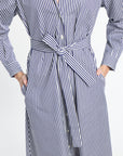 Blue and white striped dress with a belt on a light gray background