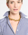 Woman wearing a gold chain necklace with a white background