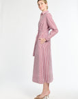 Woman wearing a pink and white striped dress on a white background