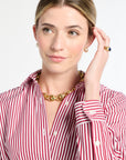Woman wearing a red and white striped shirt with a gold necklace on a white background