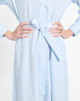 Light blue and white striped dress with a tie waist on a plain background