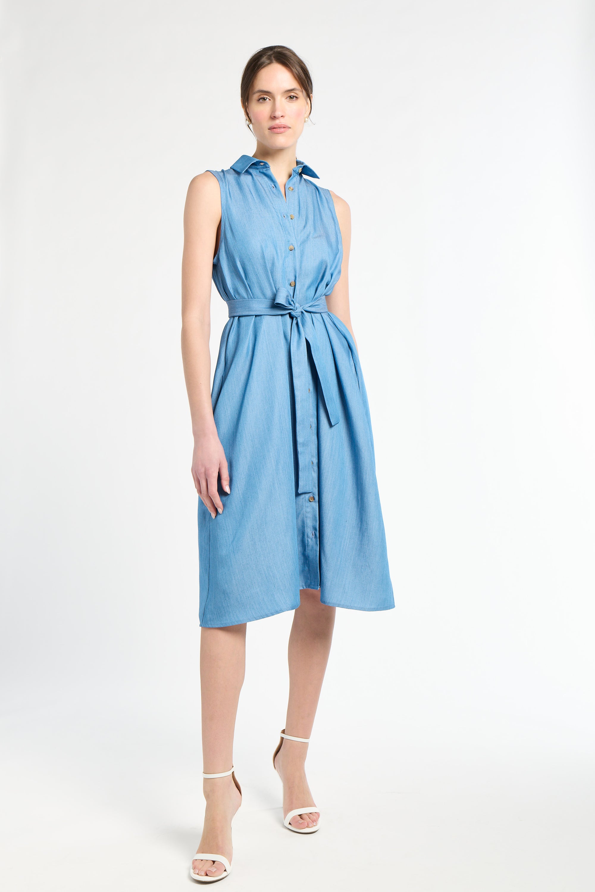Woman modeling a sleeveless blue dress against a white background