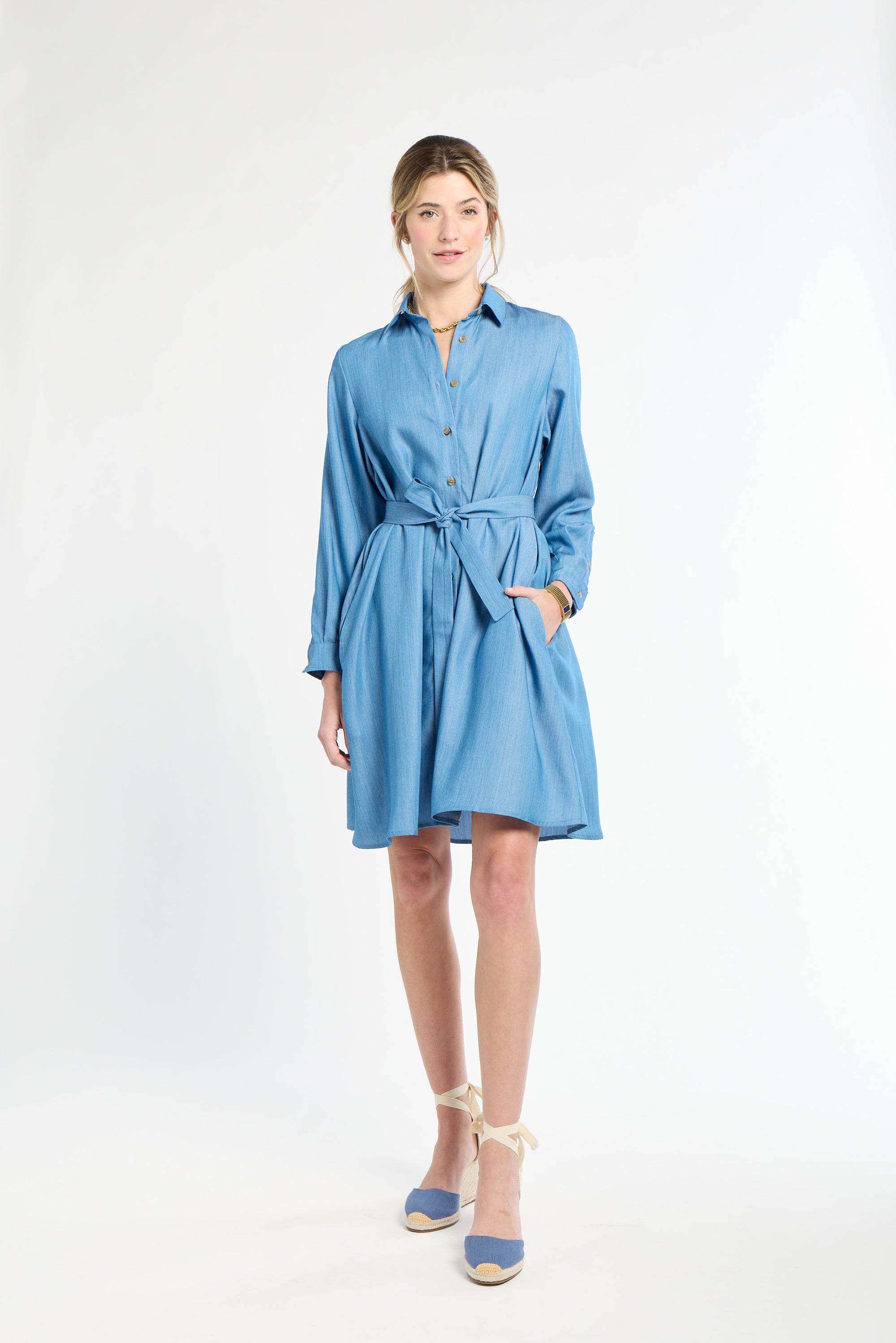 Woamn wearing blue dress and heels against white background