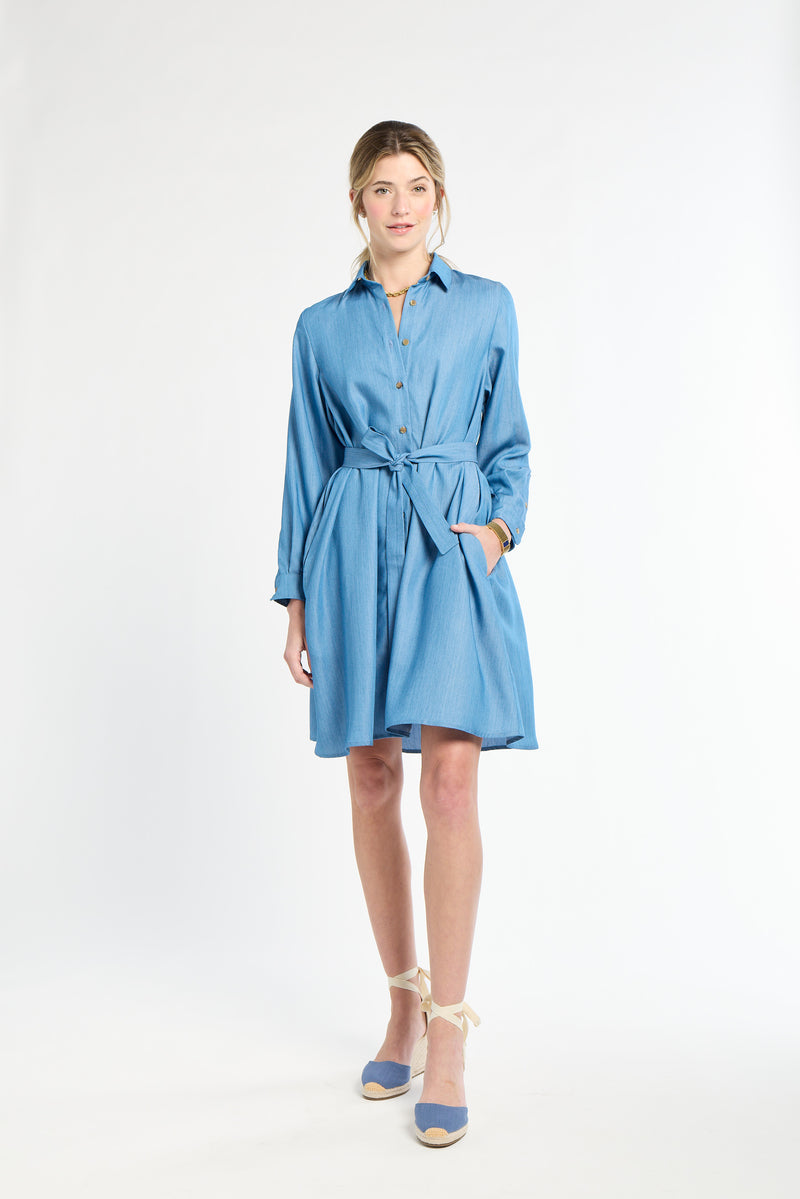 Woamn wearing blue dress and heels against white background