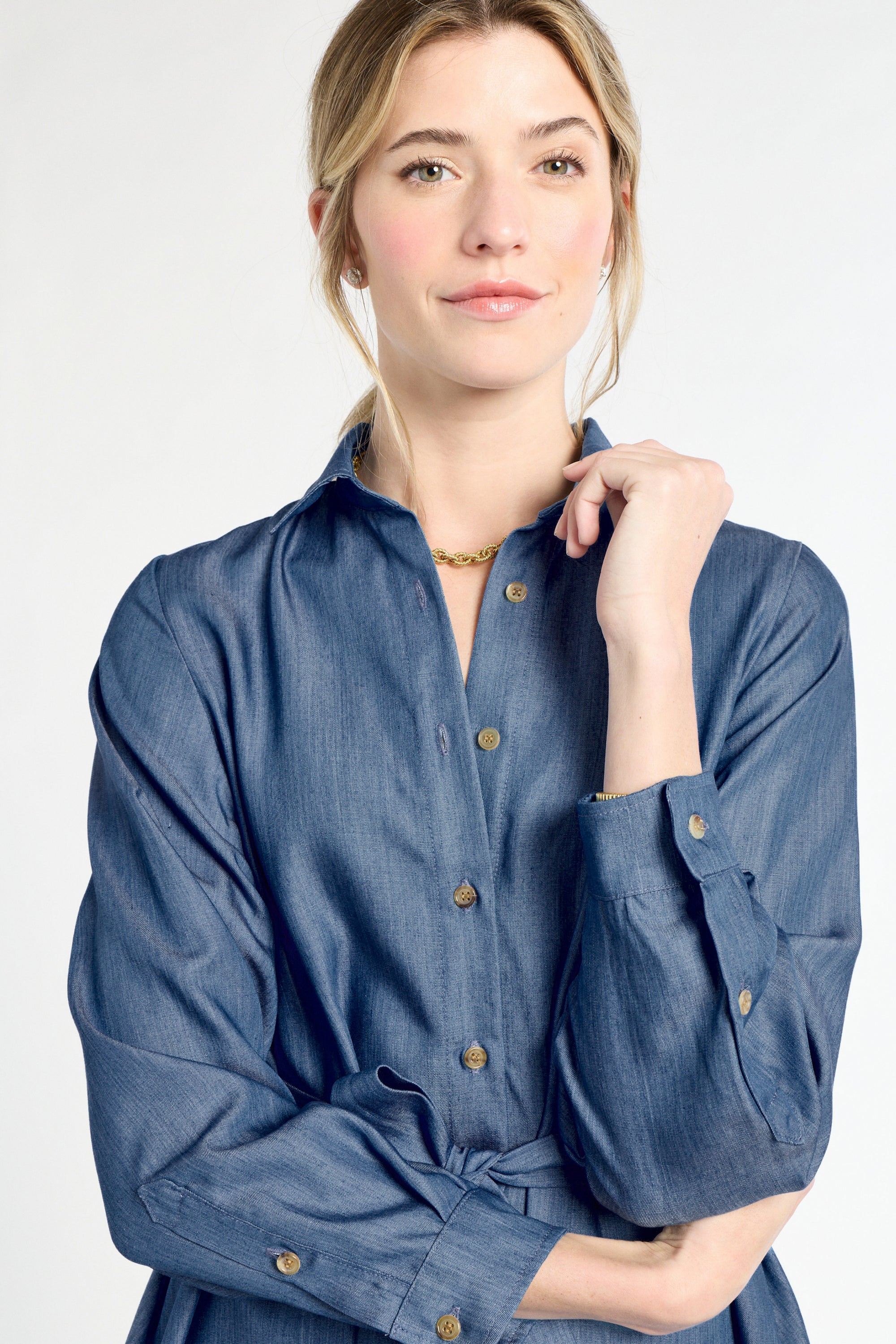 Woman wearing a blue denim dress on a white background