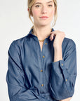 Woman wearing a blue denim dress on a white background