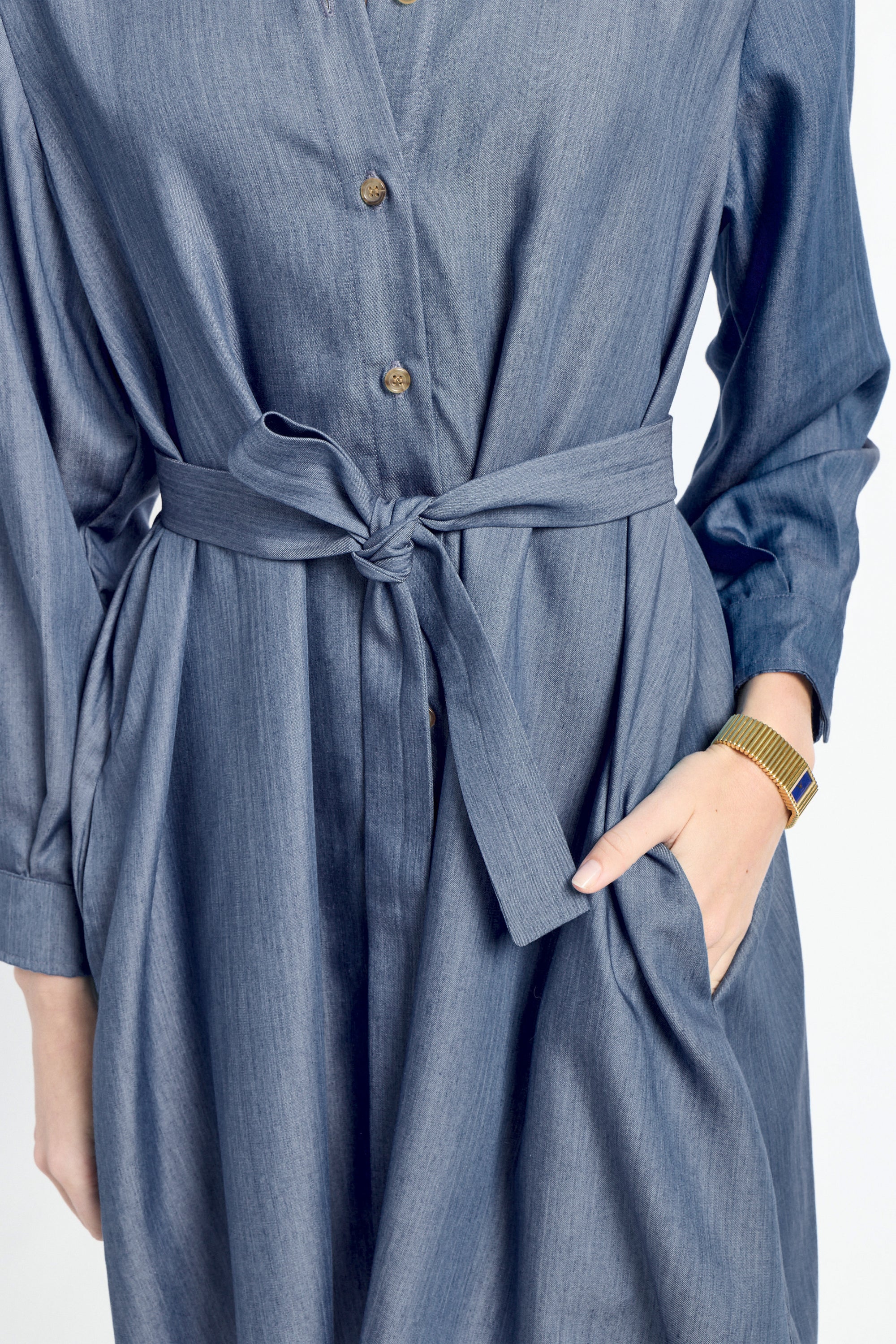 Blue dress with a belt worn by a person on a white background
