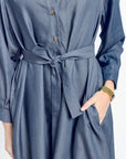 Blue dress with a belt worn by a person on a white background