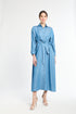 woman modeling a long blue dress with buttons on a white background