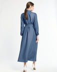 Woman wearing a blue dress standing against a white background