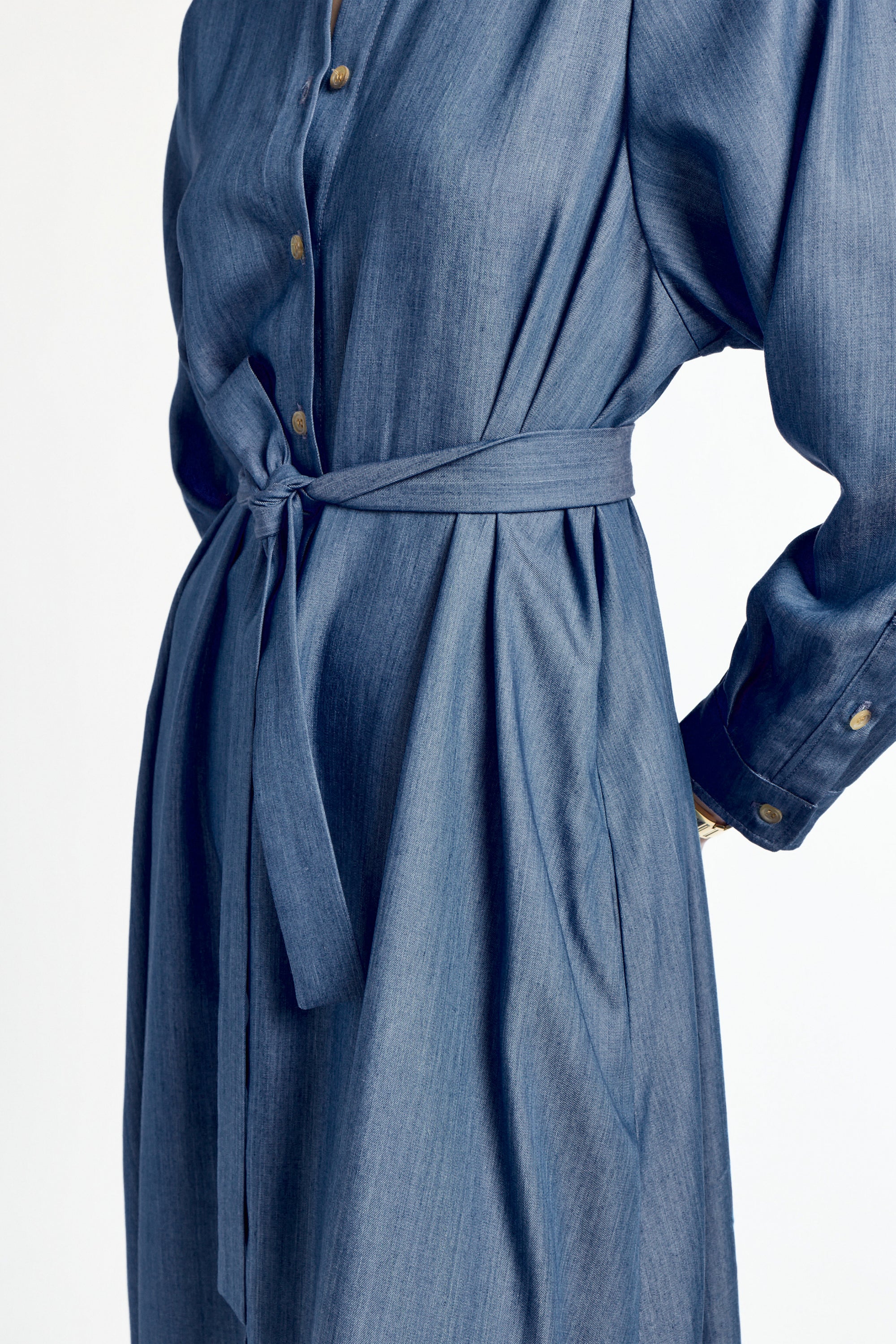 Blue denim dress with a belt on a white background