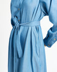 long sleeve blue dress with ribbon around waist against a white background