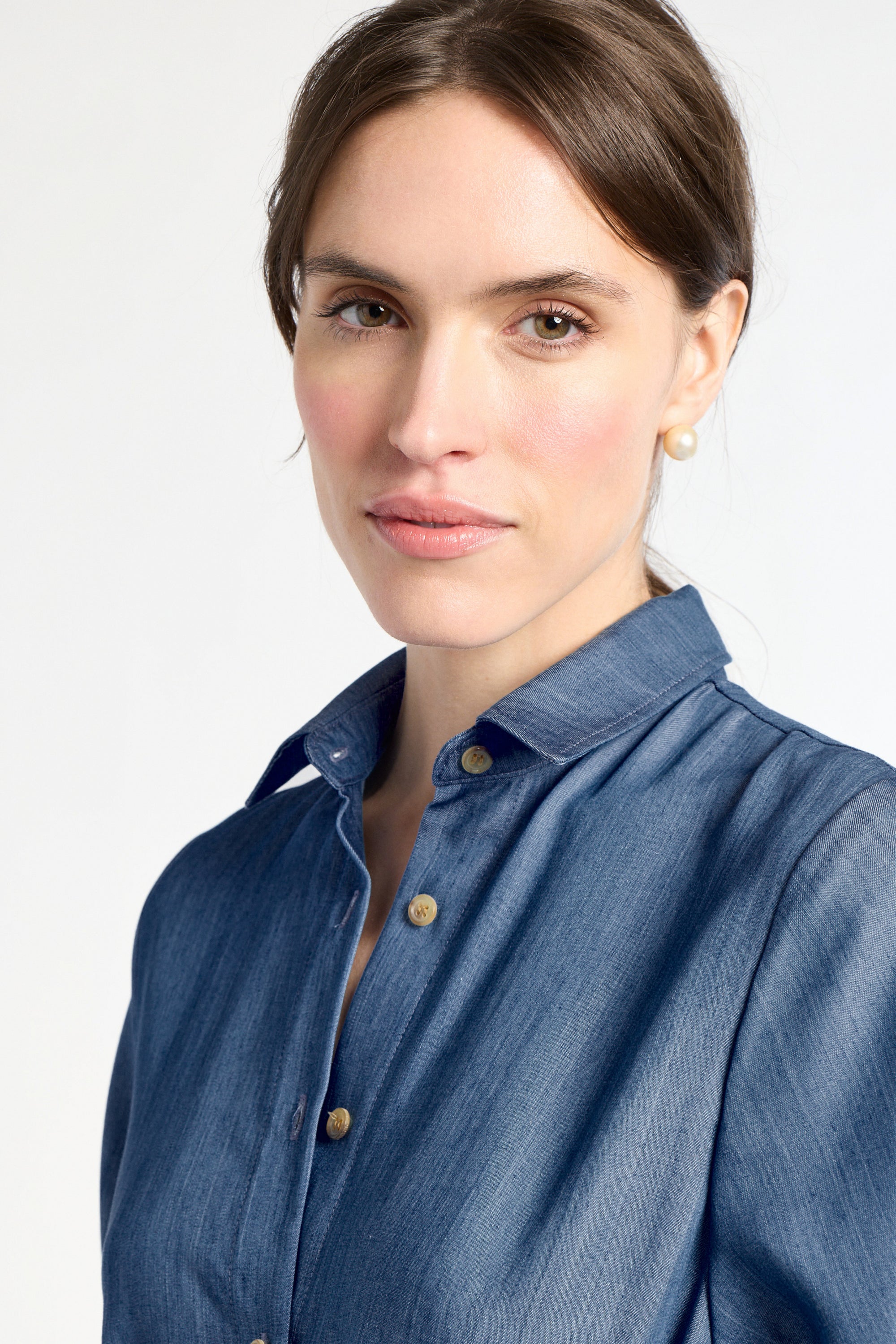 Woman wearing a blue shirt against a white background