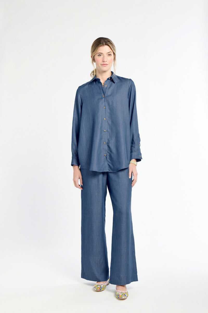 Woman wearing a blue shirt and pants on a white background