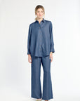 Woman wearing a blue shirt and pants on a white background