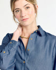 Woman wearing a blue shirt with a plain background