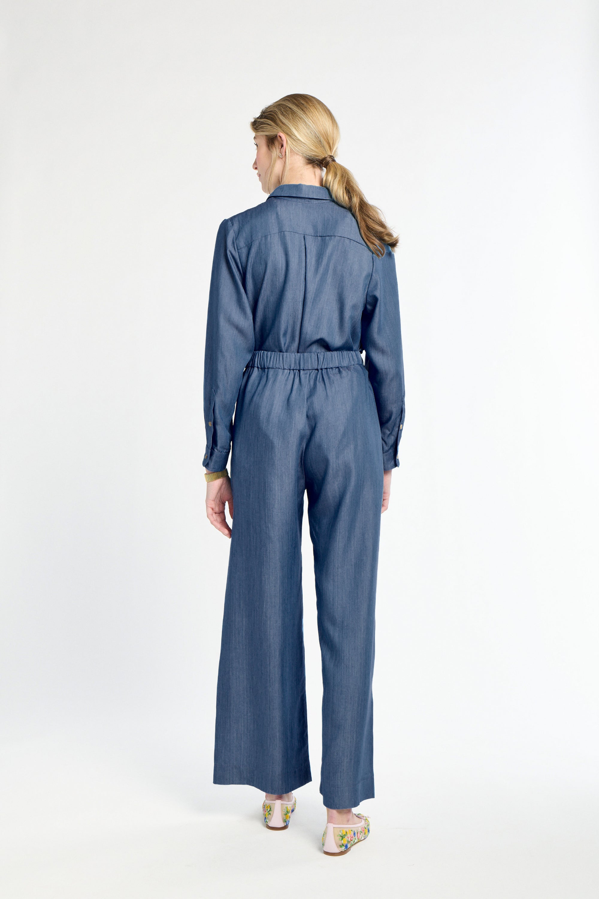 Woman wearing a blue jumpsuit on a white background