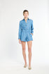 Woman modeling blue shorts and wearing flats 