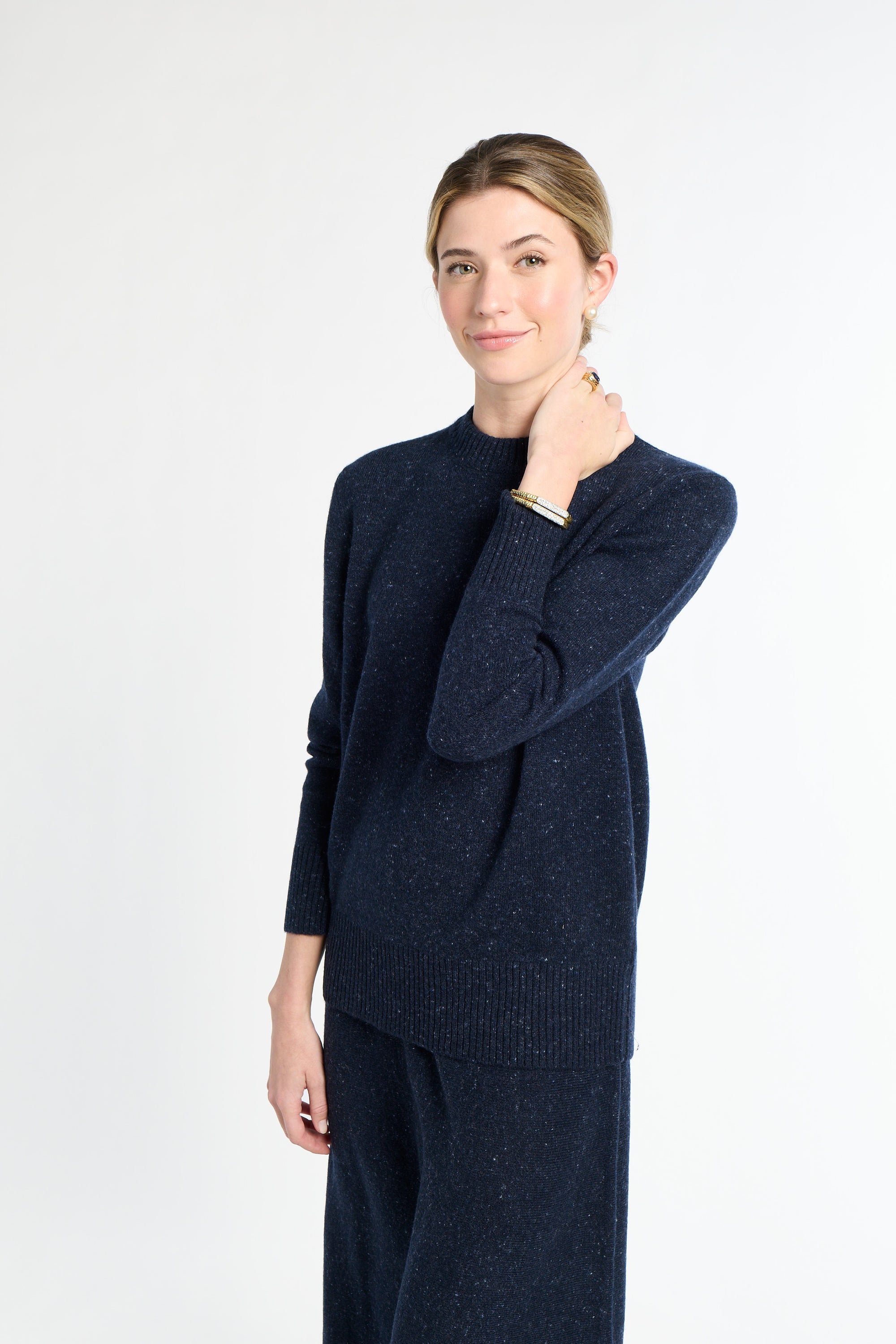 Woman wearing a navy blue sweater and pants on a white background