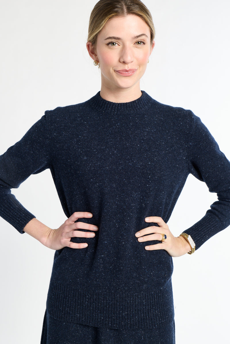 Woman wearing a navy blue sweater against a white background
