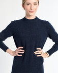 Woman wearing a navy blue sweater against a white background