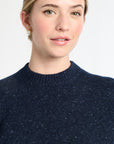 Woman wearing a dark blue sweater against a white background
