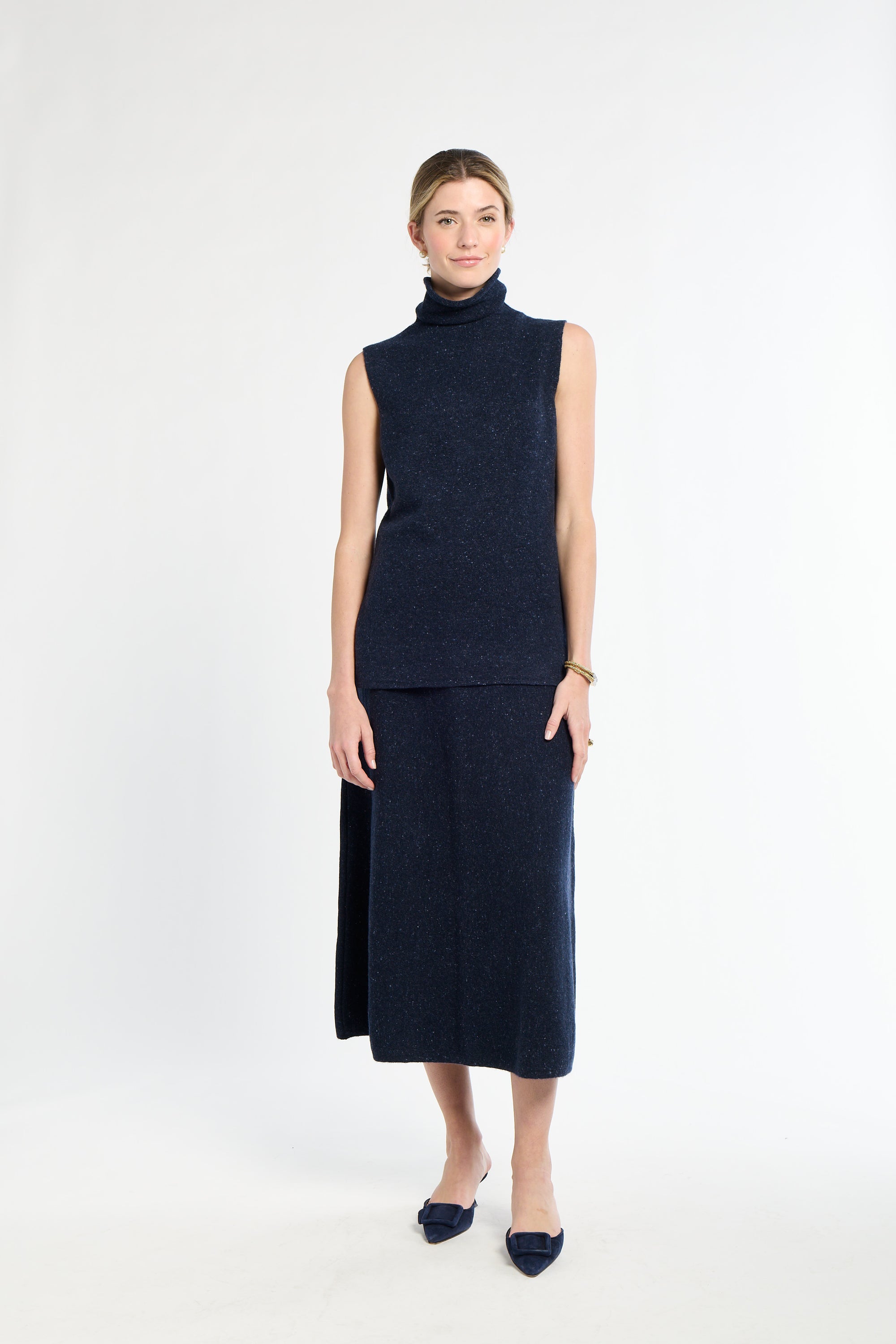 Woman wearing a navy sleeveless top and skirt set on a white background