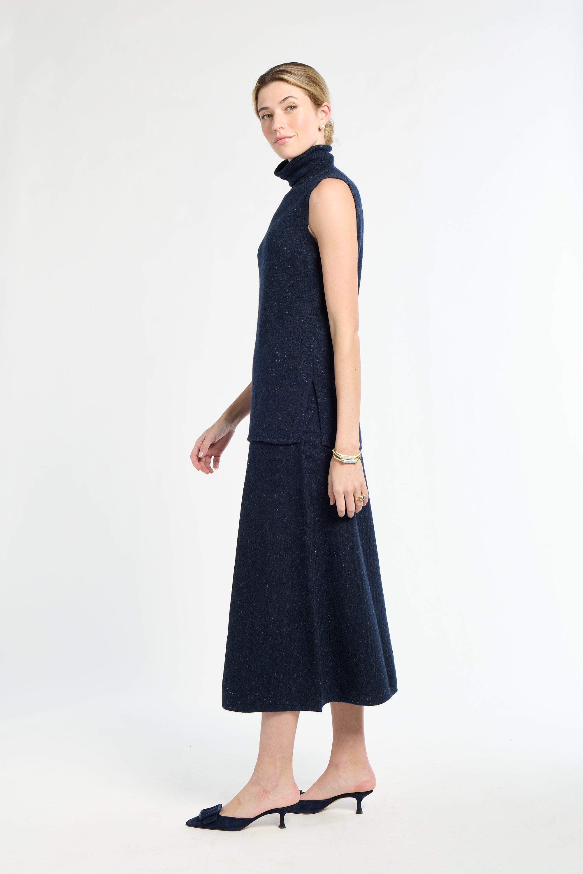 Woman wearing a navy sleeveless dress with a white background