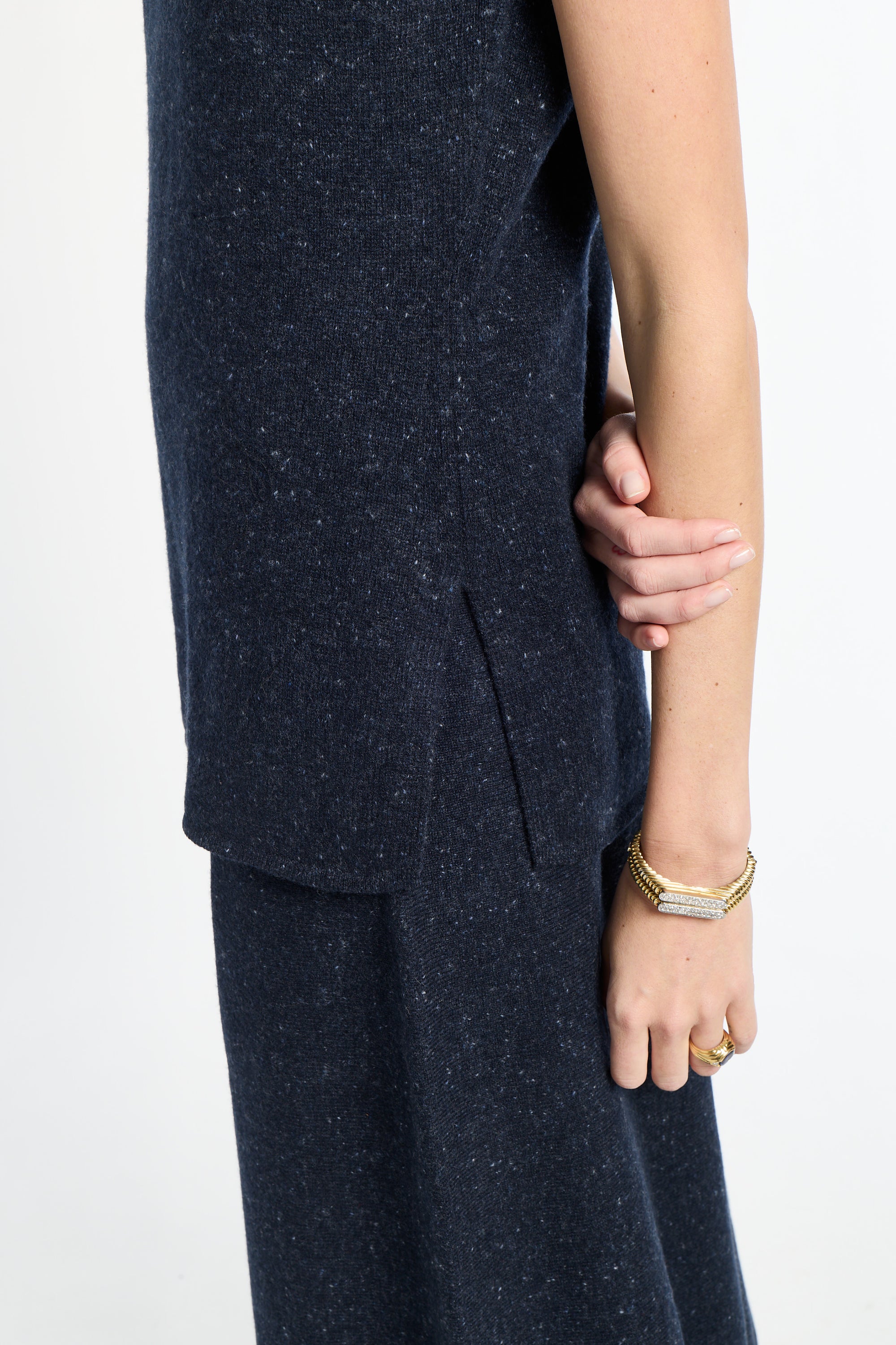 Person wearing a dark blue outfit with a plain background