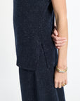 Person wearing a dark blue outfit with a plain background