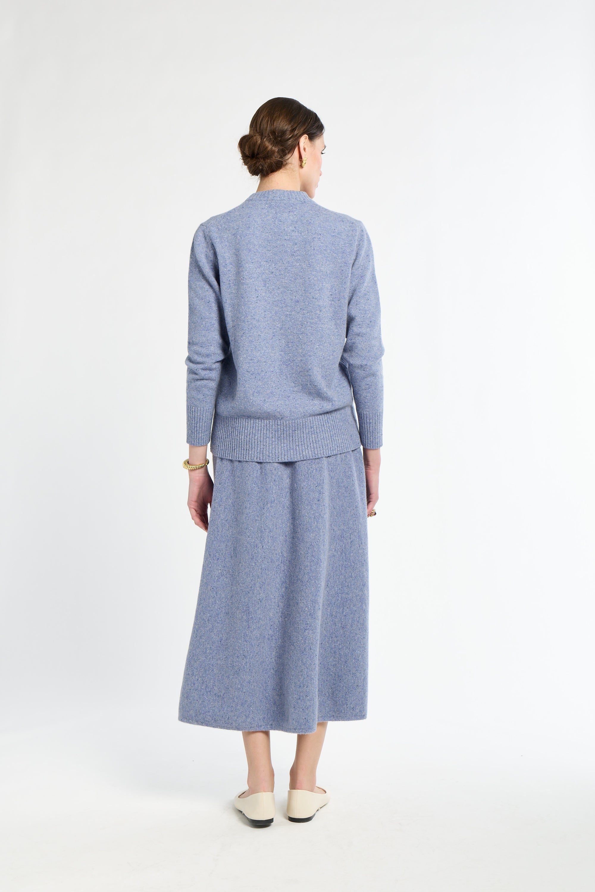 Woman wearing a light blue outfit on a white background