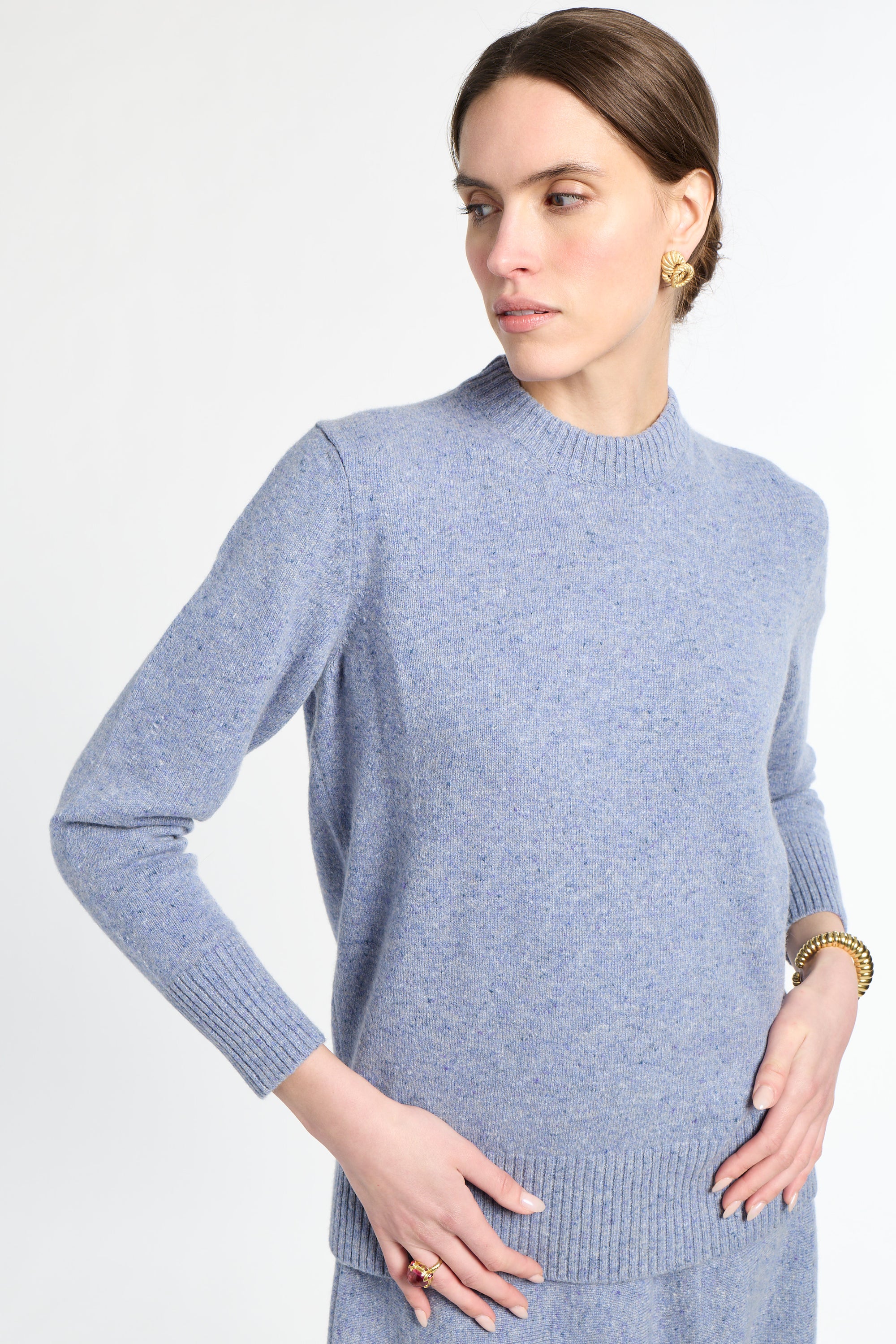Woman wearing a light blue sweater against a white background