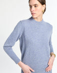 Woman wearing a light blue sweater against a white background