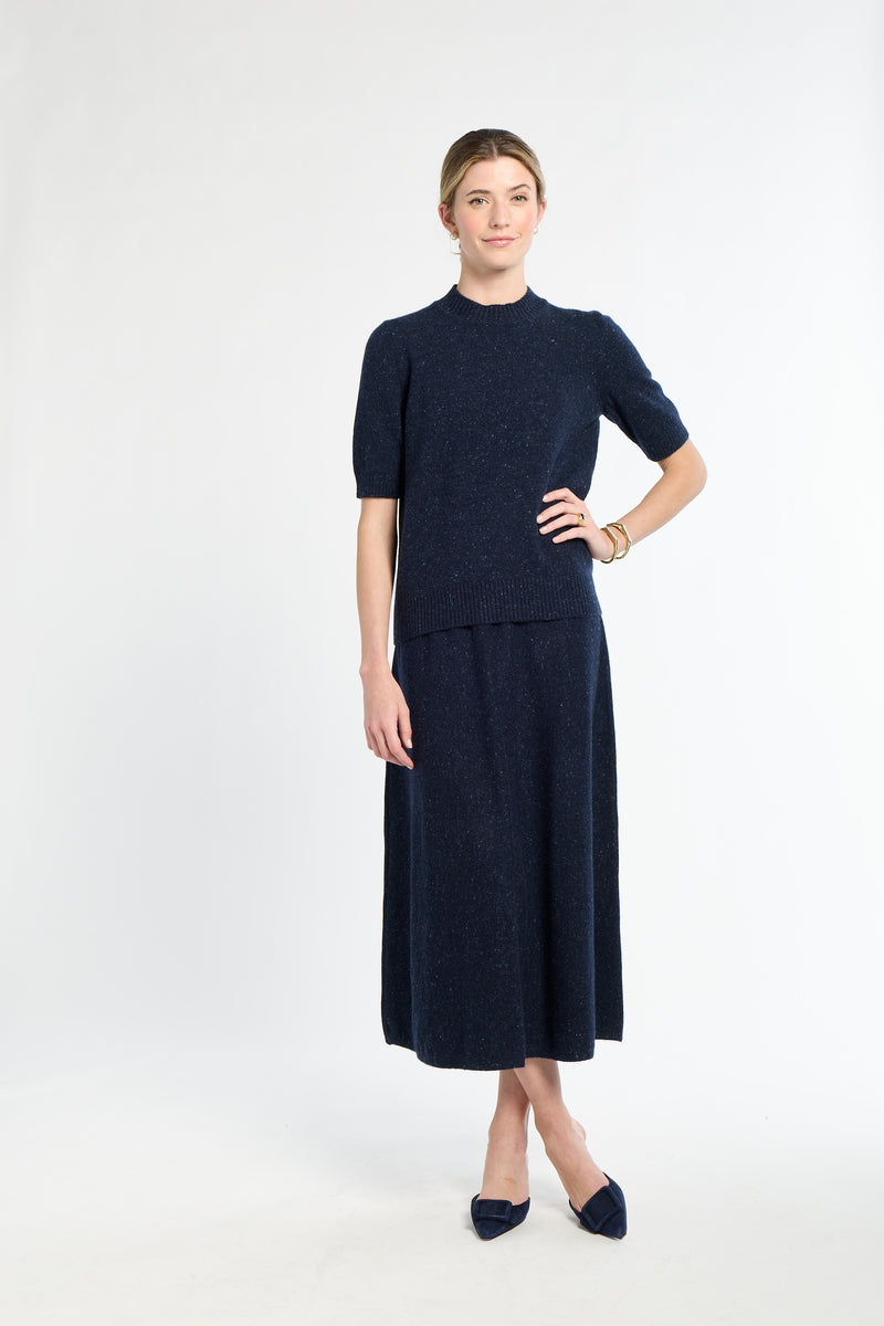 Woman wearing a navy blue dress with a white background