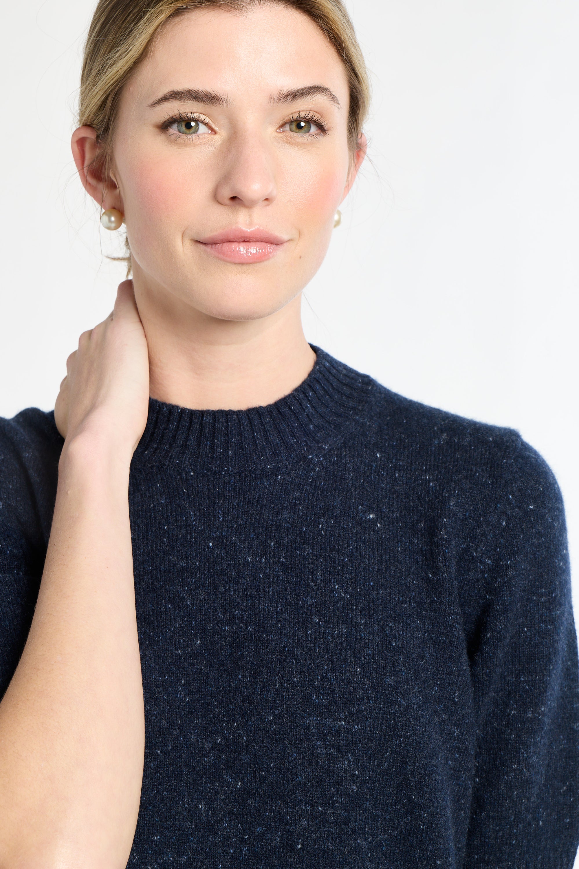 Woman wearing a navy blue sweater against a white background