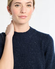 Woman wearing a navy blue sweater against a white background