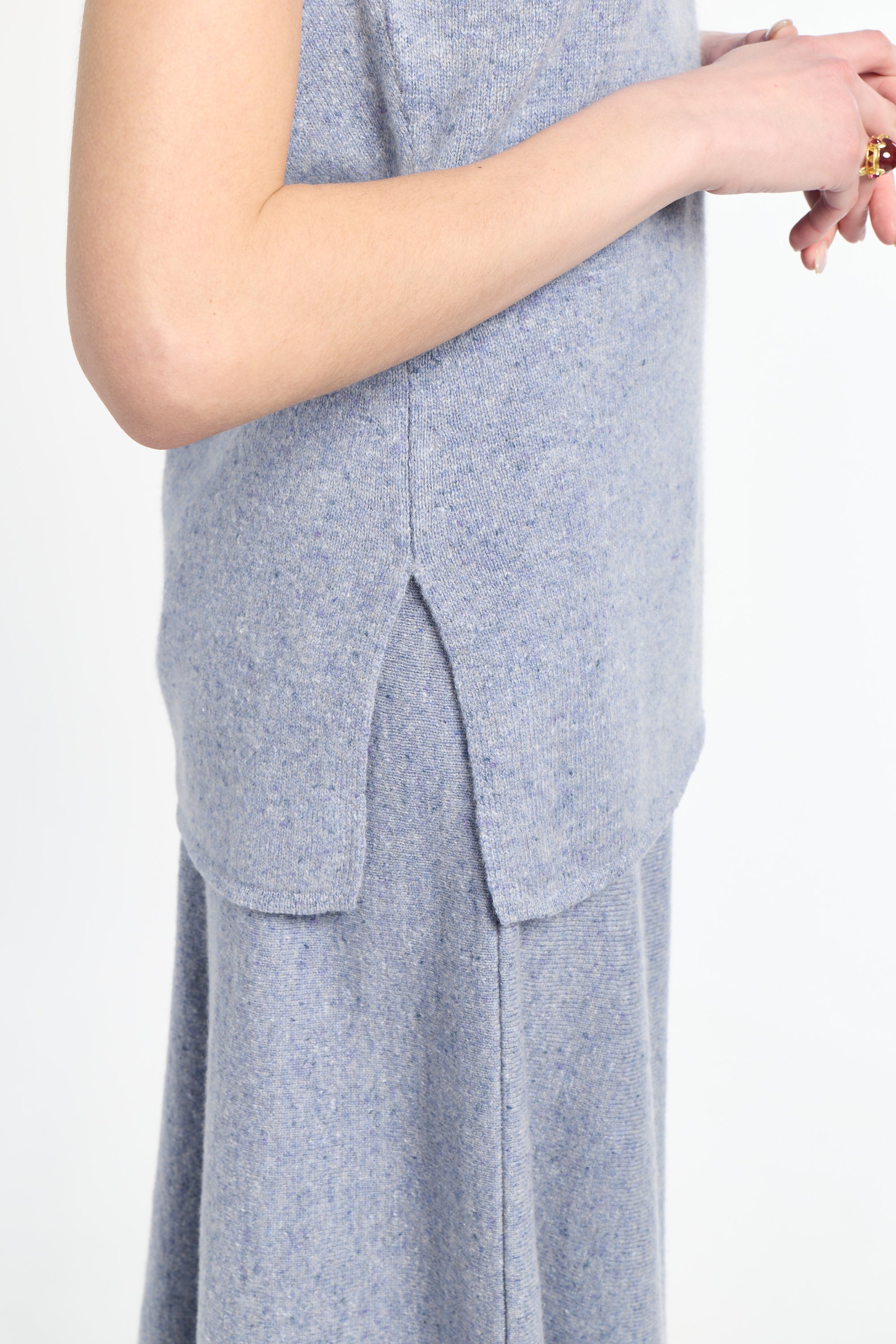 detail of side slit on light blue sweater with matching light blue knit skirt. 