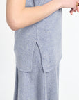 detail of side slit on light blue sweater with matching light blue knit skirt. 
